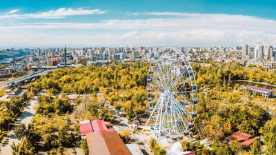 Aerial panoramic view ferris wheel in Victory Park with cityscape and buildings of Yerevan.